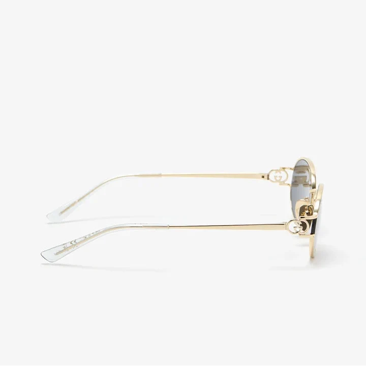 Gold metal frame luxury sunglasses with clear temple tips on a white background.