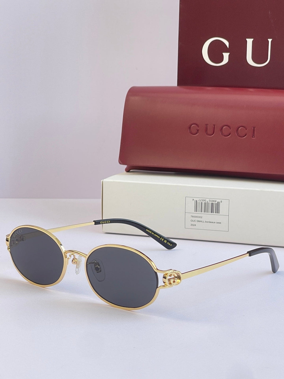 Gold rimmed round sunglasses with dark lenses and Gucci branding on the temple.